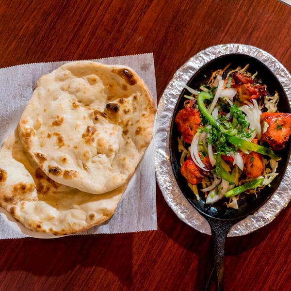 Naan bread and sizzling chicken tikka with onions and peppers from Noorani Kabab House.